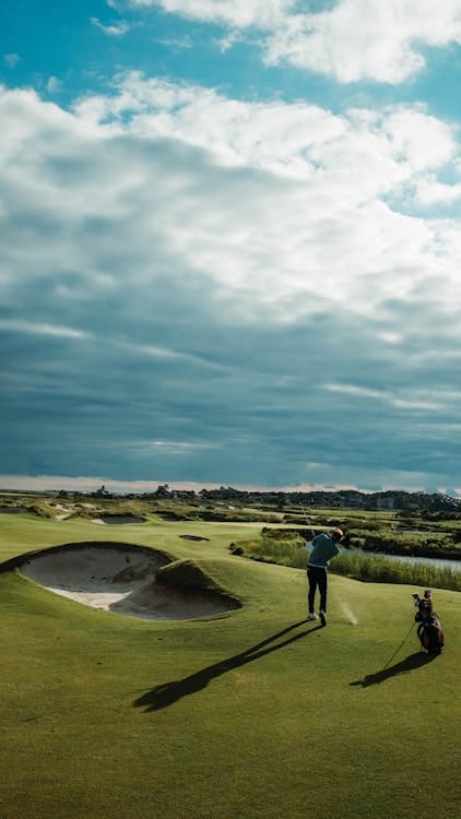 Golfeur jouant sur un parcours panoramique sous un ciel nuageux