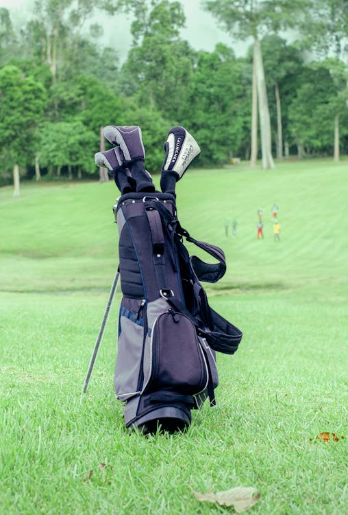 Sac de golf sur un parcours verdoyant avec golfeurs en arrière-plan